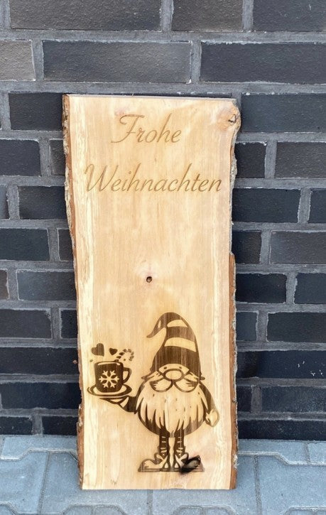 Eine Weihnachtsholzbohle mit einem Weihnachtsmann und einen Schriftzug "Frohe Weihnachten".